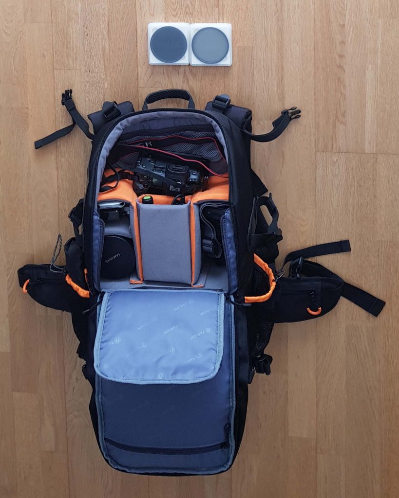 Equipo fotográfico ordenado en una mochila fotográfica